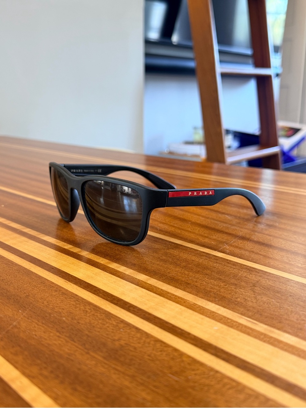 PRADA Matte Black Sunglasses with Red Temple Accent